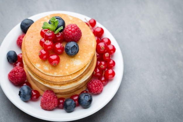 Stack of pancakes with blueberry and fresh berry.