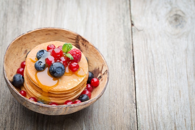 Stack of pancakes with blueberry and fresh berry.