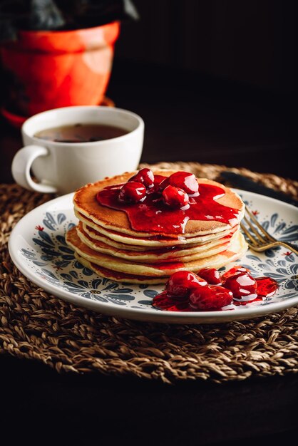 Stack of pancakes with cornelian cherry jam on plate