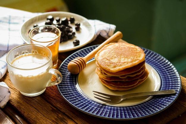 stack of pancakes with honey and blueberry