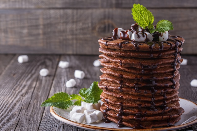 Stack of pancakes with marshmallow and chocolate syrup