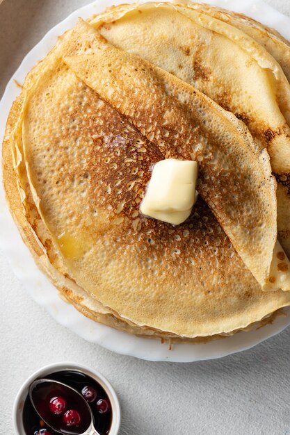 A stack of pancakes with a piece of melted butter