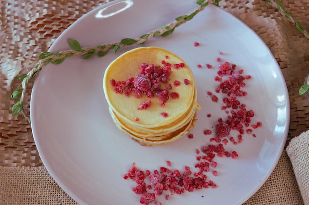 A stack of pancakes with raspberries