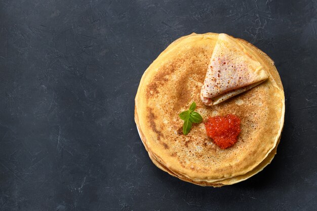 Stack of pancakes with red caviar, top view