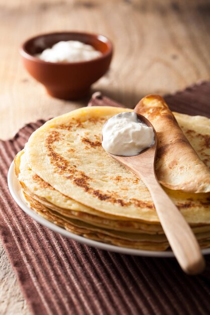 Photo stack of pancakes with sour cream