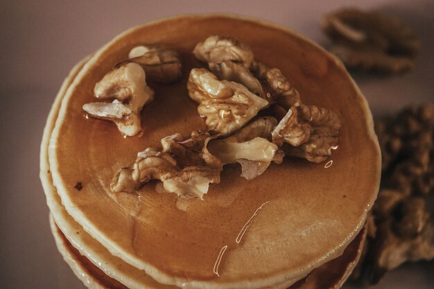 A stack of pancakes with walnuts in syrup