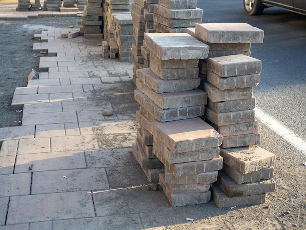 A stack of pavers tiles on the ground Road works Laying tiles on the sidewalk