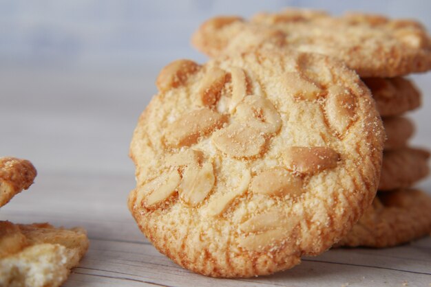 Photo stack of peanut cookies on wooden background.