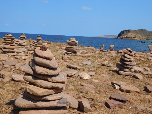 Stack of pebbles on beach against sky