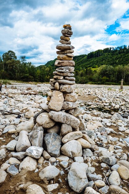 Stack of pebbles on landscape against sky