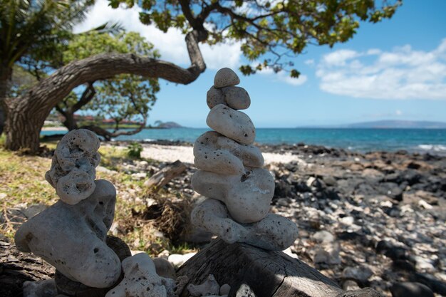 Pila di ciottoli di pietra sullo sfondo del mare per spa, equilibrio, meditazione e tema zen.