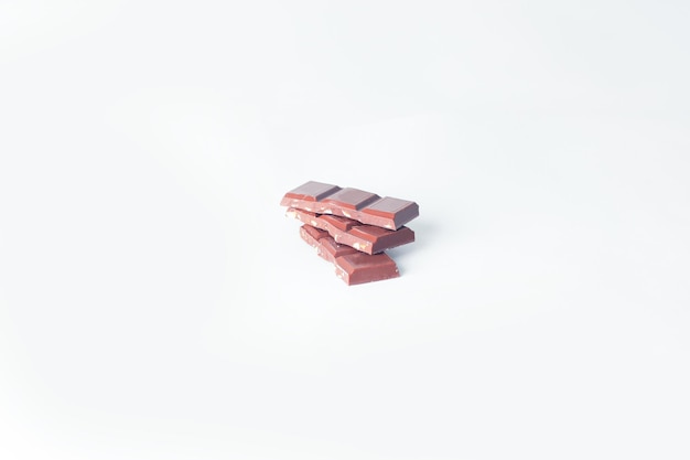 Stack pieces of chocolate with nuts isolated on white