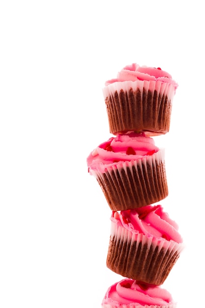 Photo stack of pink cupcakes on white background.