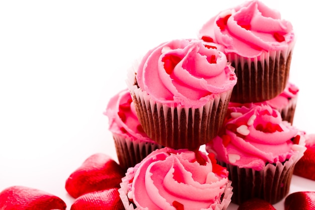 Stack of pink cupcakes with engagement ring on top.