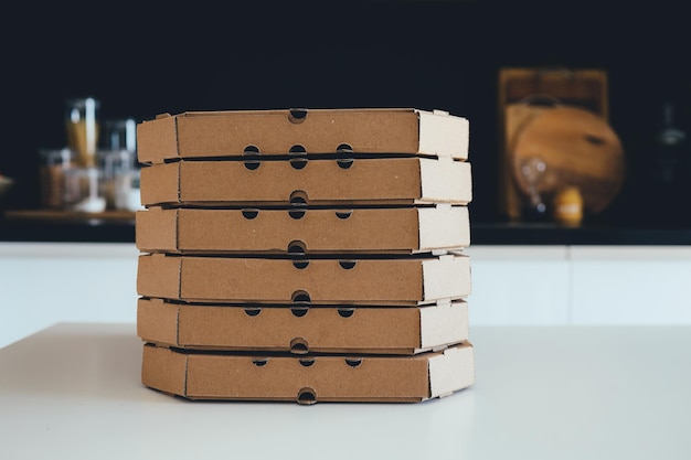 Photo a stack of pizza boxes in the kitchen