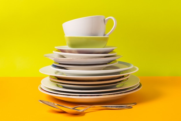 Photo stack of plates, dishware on colorful background.