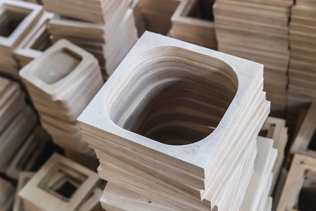 A stack of plywood frames are in the workshop foreground focus