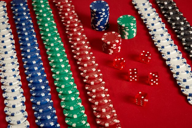 Pila di fiches da poker su sfondo rosso al casinò