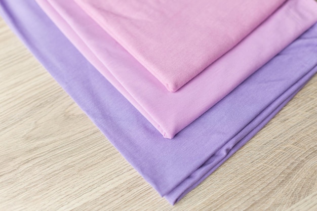 A stack of purple and pink cotton fabric with the word love on the top.