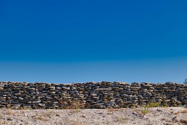 Stack of rocks against clear blue sky