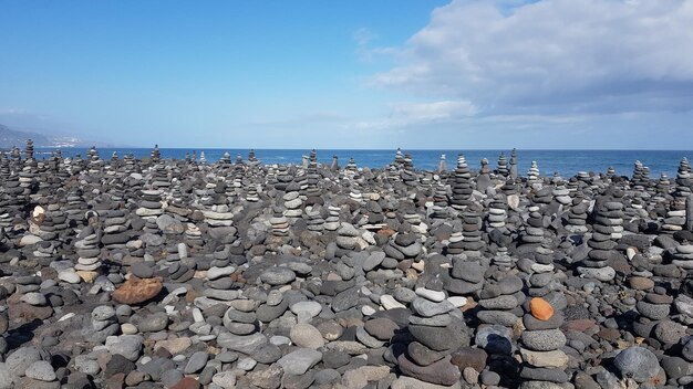 Stack of rocks on beach against sky