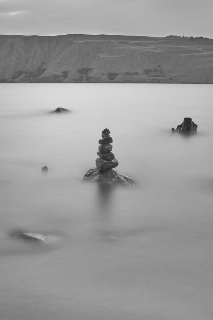 Foto una pila di rocce nel lago contro il cielo