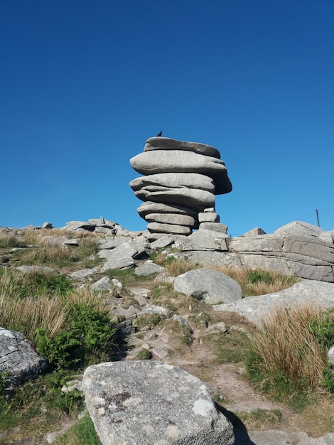 Foto una pila di rocce sul paesaggio contro un cielo blu limpido