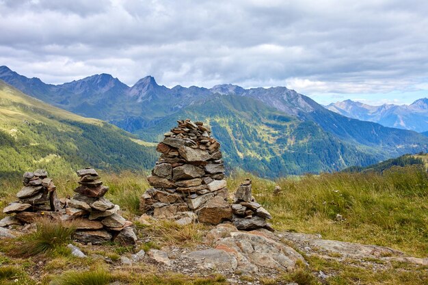 Stack of rocks on mountain against cloudy sky