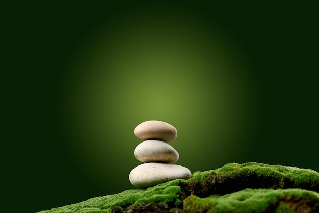 Stack of round stones on green moss green background Podium to showcase products