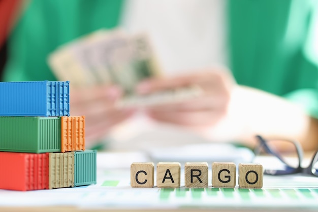 Stack of several containers cubes with the word cargo and glasses on financial data documents