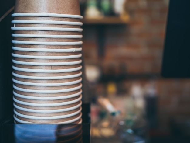 Stack of small brown paper cups in cafe