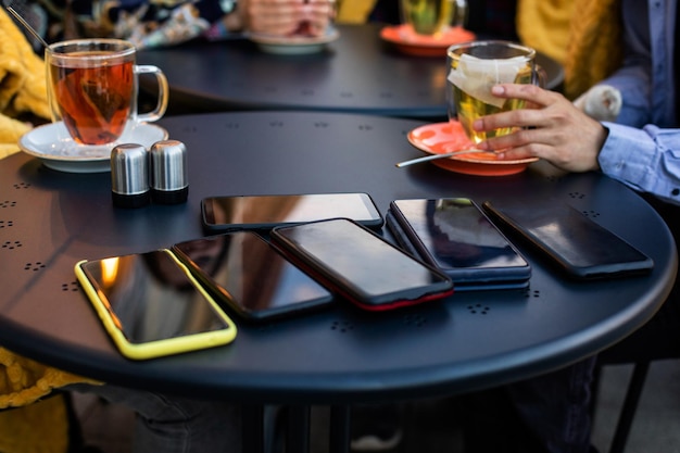 カフェの黒いテーブルにスマートフォンのスタック