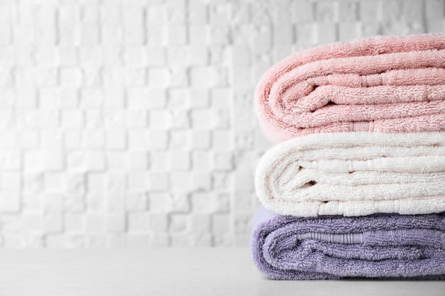 Stack of soft bath towels on table Space for text