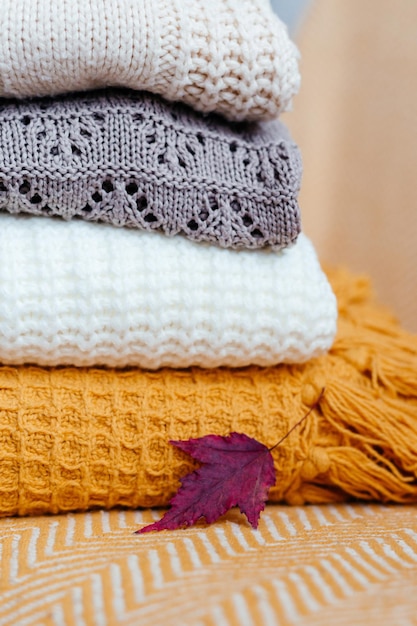 Stack of soft warm plaids and an autumn leaf closeup