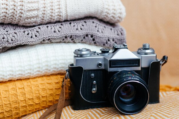 Stack of soft warm plaids and retro camera closeup