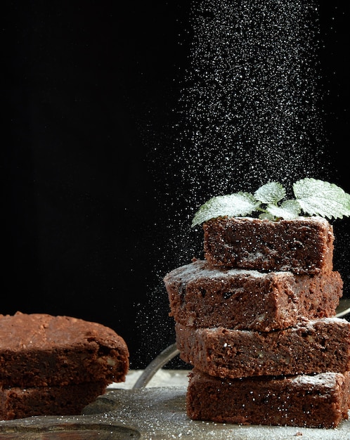 Stack of square baked brownie chocolate cake slices