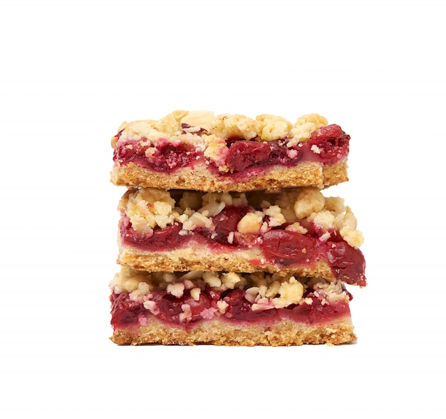 Stack of square baked slices of cramble with red cherry