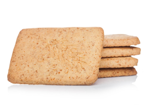 Foto pila di grano croccante organico quadrato e cracker salati di cinque grani su fondo bianco