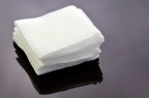 Photo stack of sterile gauze pad on dark background.