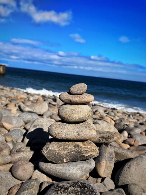 Stack of stones on beach against sky