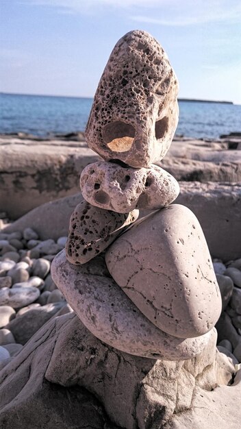 Stack of stones on beach against sky