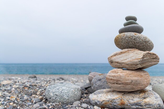 Stack of stones on beach against sky