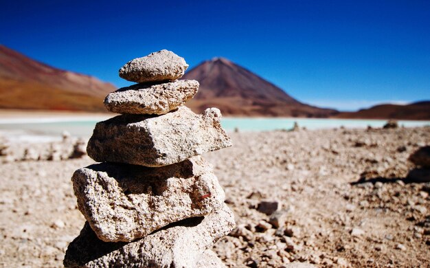 Stack of stones on rock against sky