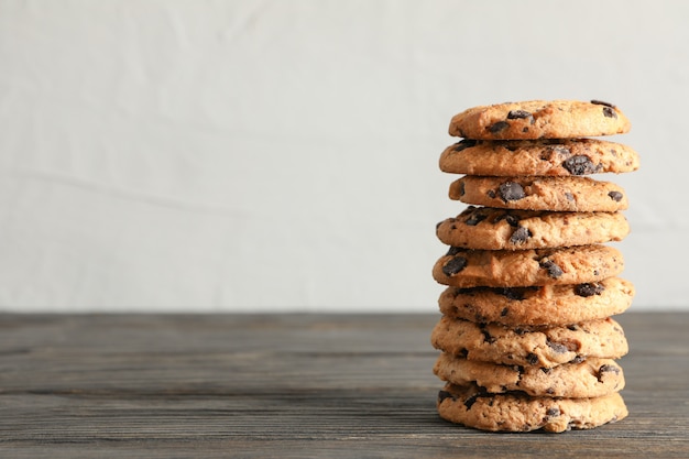 Stack of tasty chocolate chip cookies on wooden table. Space for text