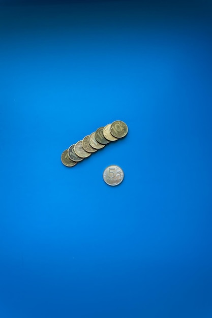 stack of ten ruble coins leeit on left on blue background isolated free space for text Russian rub