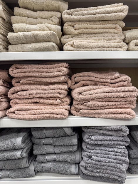 Stack of terry towels in different colors on shelf in store