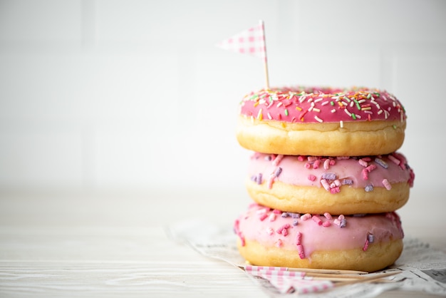 A stack of three donuts in glaze