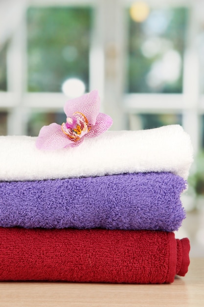 Stack of towels with fragrant flower over window