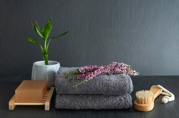 A stack of towels with a plant next to it