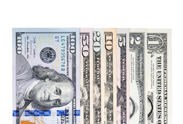 米ドルのバックラウンドのスタックノートは、白で分離されたすべての米ドルの価値に直面します